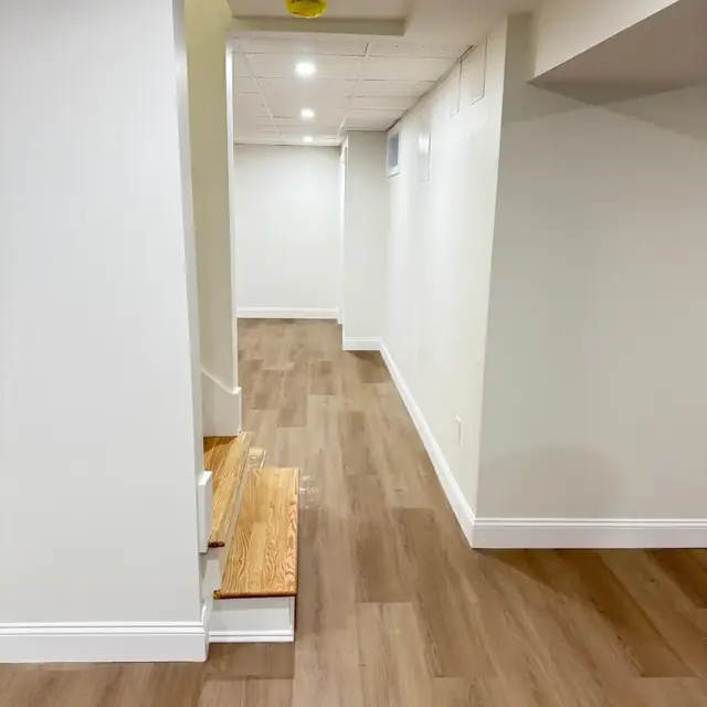 Finished basement hallway with new stairs and baseboard trim