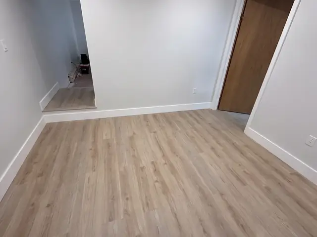 Finished basement living area with new flooring and trim in Ashland, MA